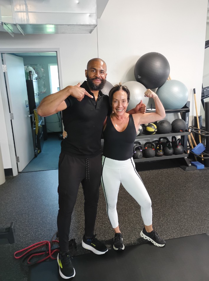 Tim smiling with a client in the gym after a training session