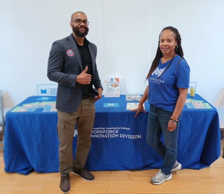 Tim Collins and an MCC representative beside the wellness workshop table