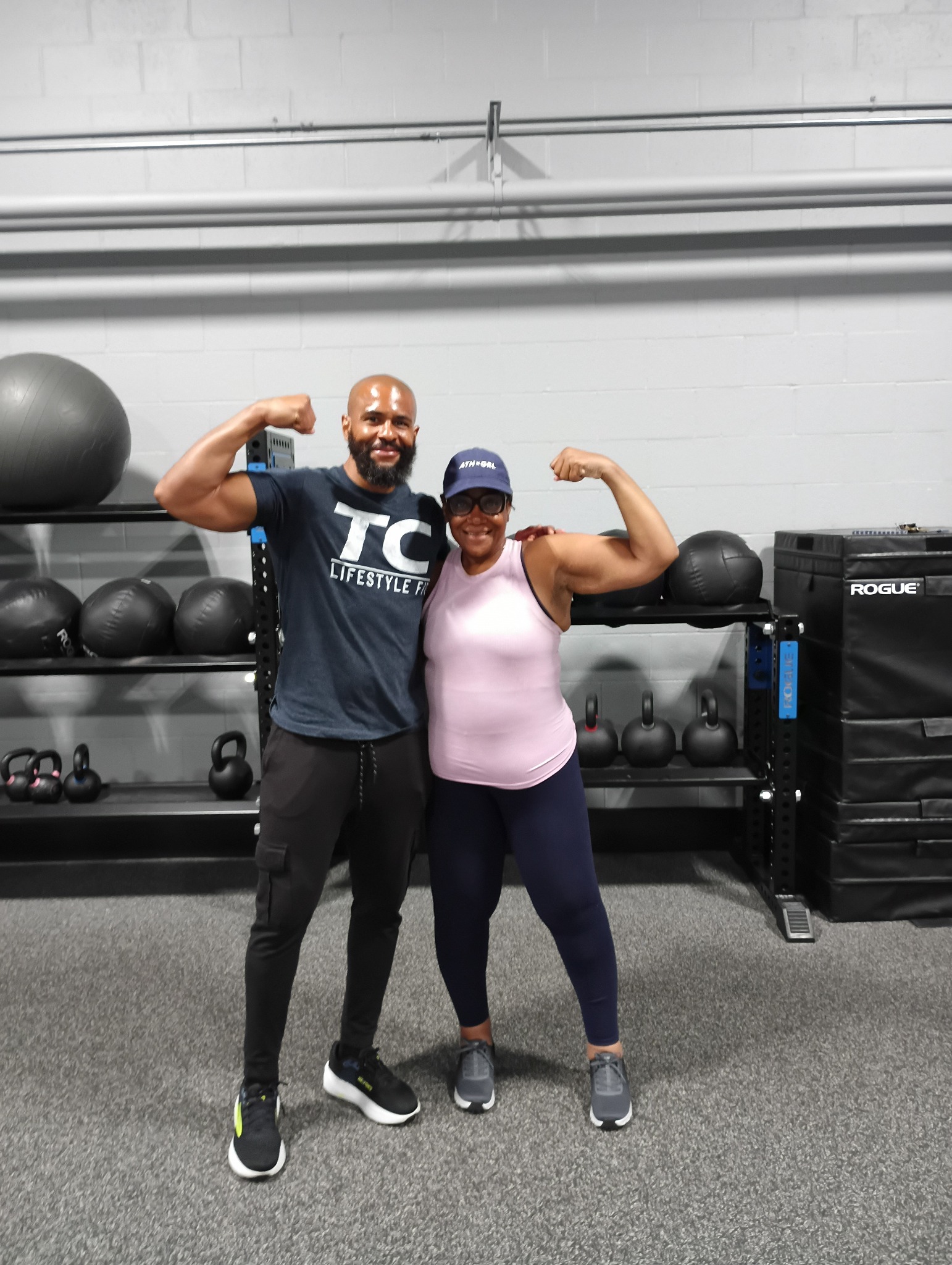 Tim and a client celebrating their training in the gym